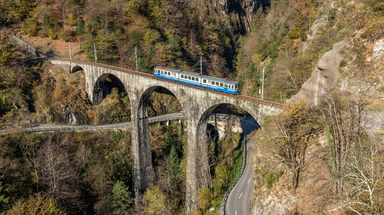 A train crosses an arched bridge on the Vigezzina-Centovalli Railway