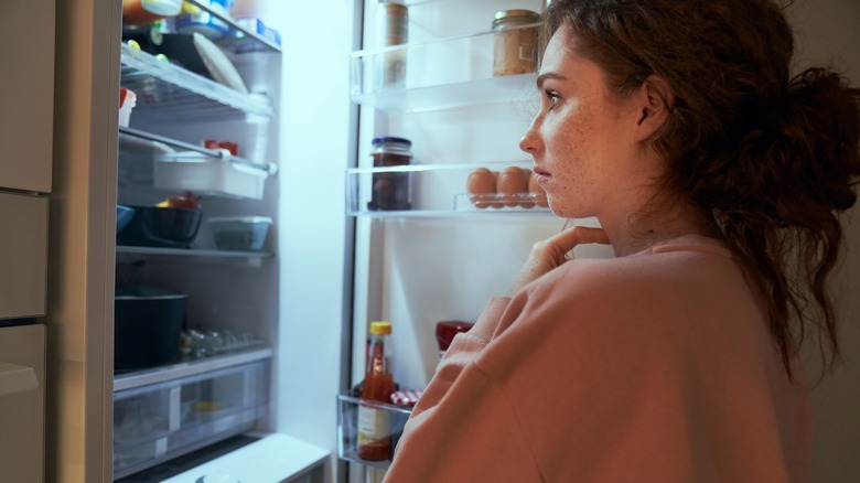Woman opening fridge