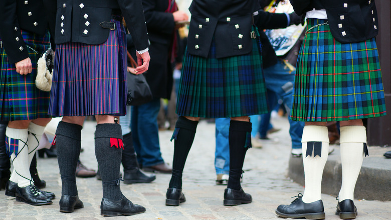men dressed in kilts in different tartans