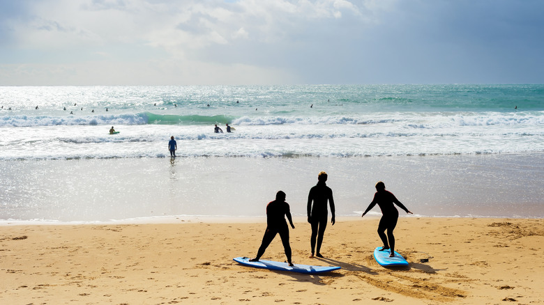 two people taking surfing lesson with instructor