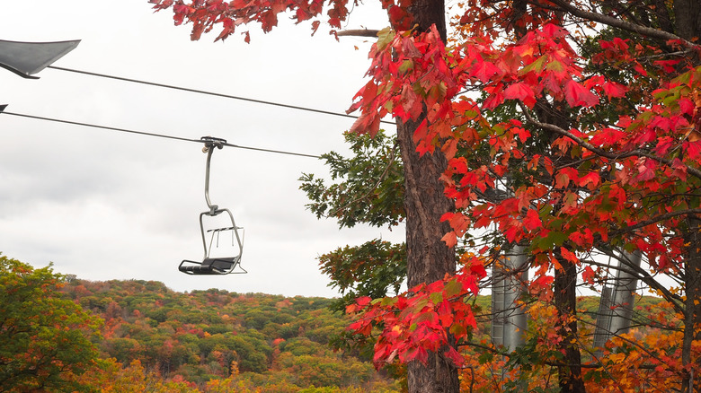 A chairlift traveling through fall foliage.