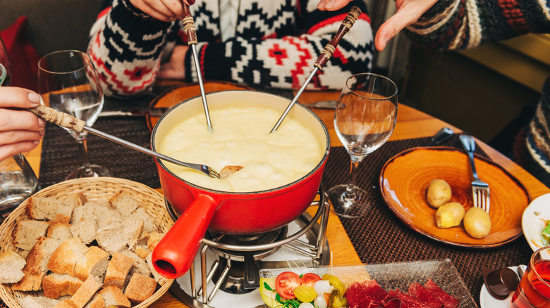 Friends sharing a fondue pot