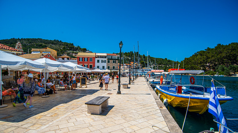 People at outside restaurant tables by the water