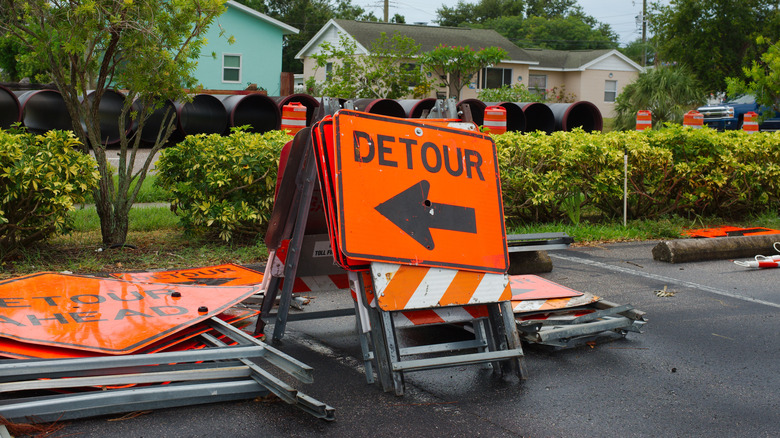 An orange detour construction sign