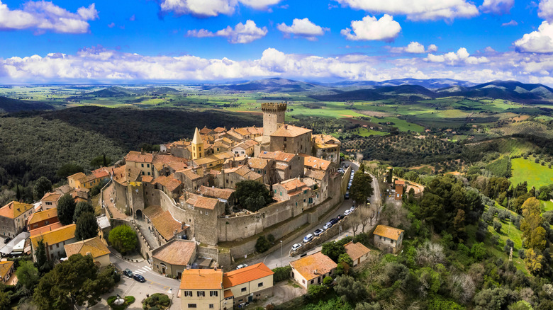 A medieval Italian village on a hill with a wall around it