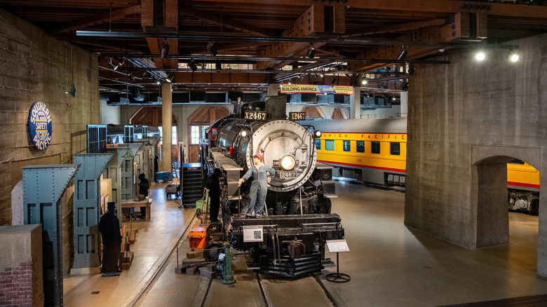 A mannequin of a railroad worker stands on a locomotive in the California State Railroad Museum