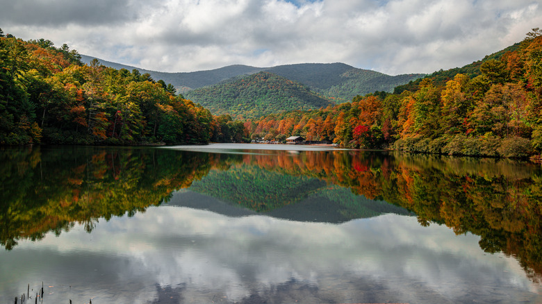 Beautiful scenic autumn forest and sky reflecting off still lake water at Vogel State Park in Georgia