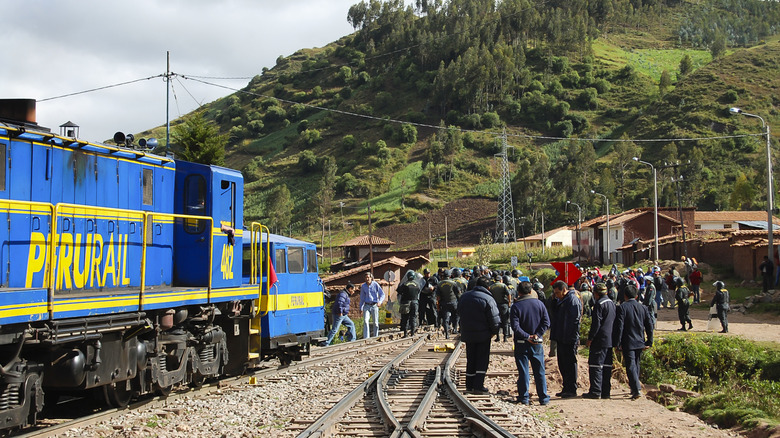 Locals protesting next to a Peru Rail train