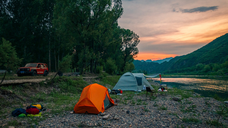 Camp by the river in the setting sun