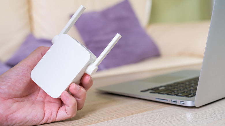 A hand holding a portable router