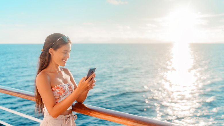 A woman using her phone on a cruise ship