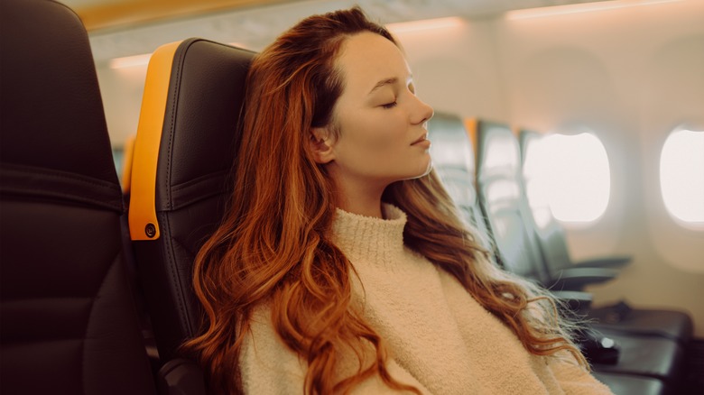woman closing eyes on flight