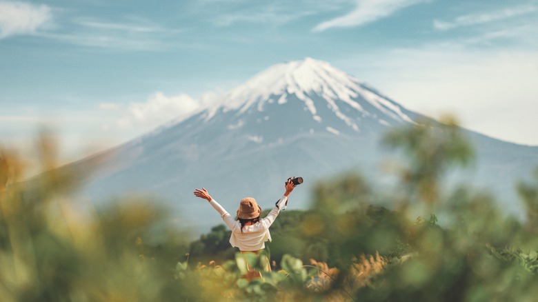 Happy traveler raising hands in Japan