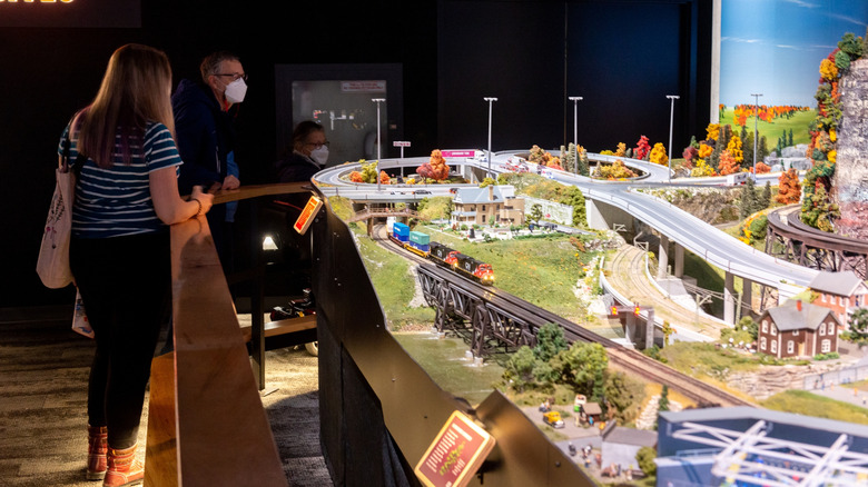 Visitors look at miniature attraction at Little Canada exhibition