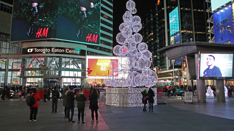 People enjoying decorations in Yonge-Dundas Square on a cold November night