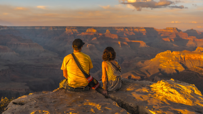 Couple sitting at sunset of the Grand Canyon