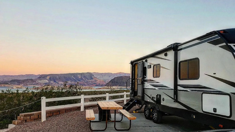 RV parked by lake at sunset