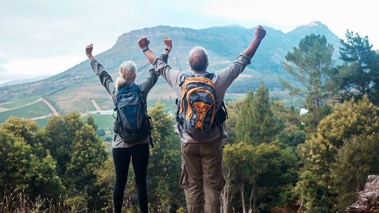 Elderly couple stretching on hike