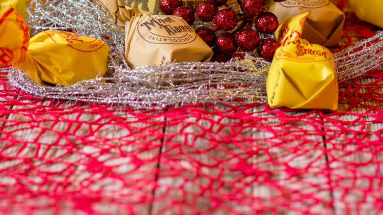 A bottle of Strega liqueur with Christmas decorations around it
