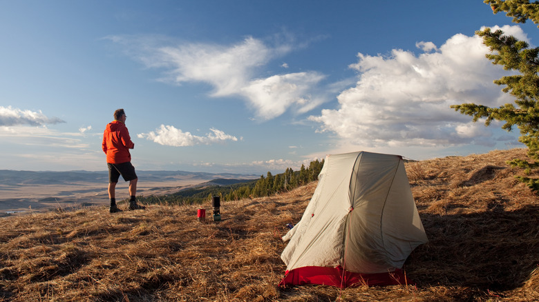 A man with a solo tent camping in a prairie