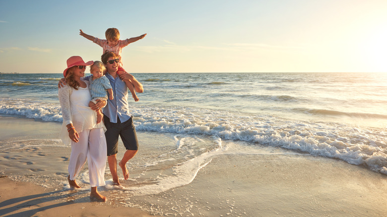 Happy family, beach holiday and walking, smile for vacation on tropical island