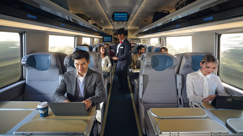 Passengers working on laptops on a fast train