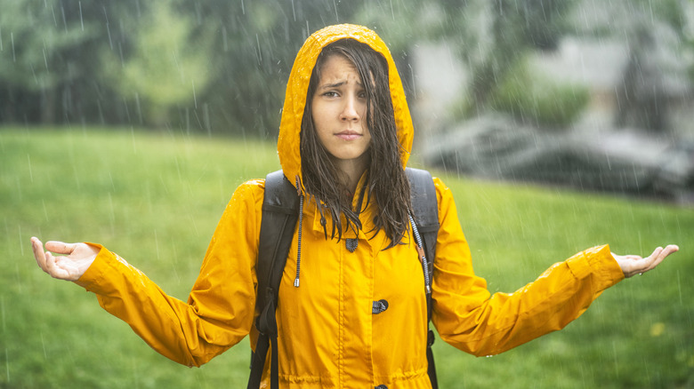 A hiker has a confounded expression while standing in the rain
