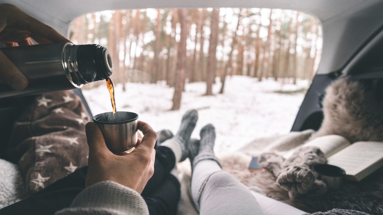 A couple enjoying the cozy back seat of a car in winter