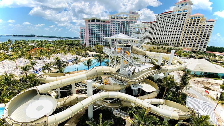 tall white resort buildings and the Baha Bay Waterpark near ocean with lush grounds