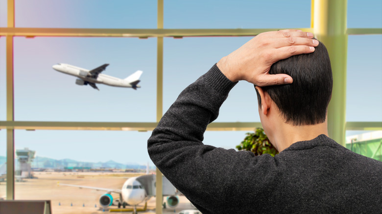 a man watching an airplane leave without him