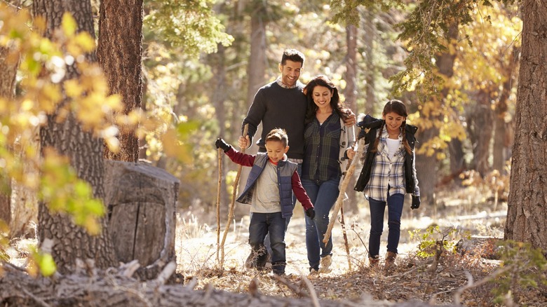 family hiking in autumn forest