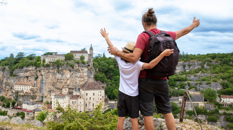 man and child looking at a view of a perched town