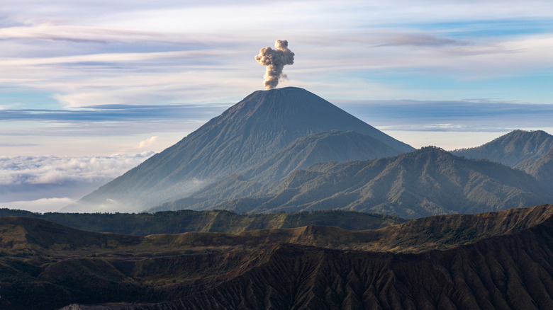 Smoking volcano with cloudy background