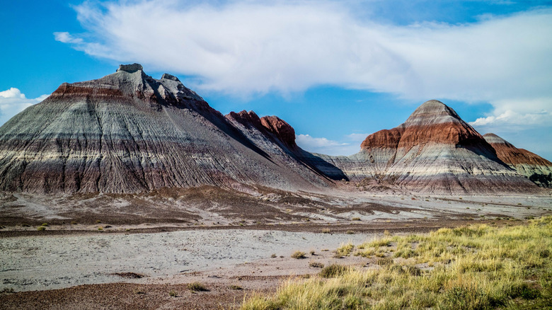layered desert hill formations, blue sky with clouds