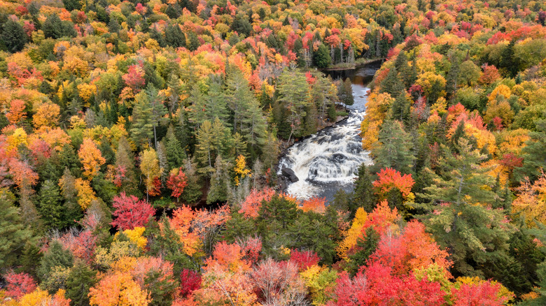 An aerial view of Buttermilk Falls Sargent Ponds Wild Forest surrounded by fall foliage in Long Lake, New York