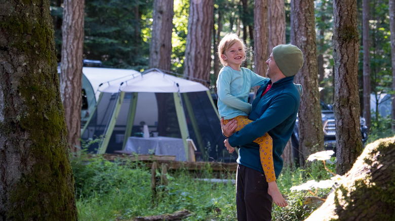 father and daughter at wooded campground