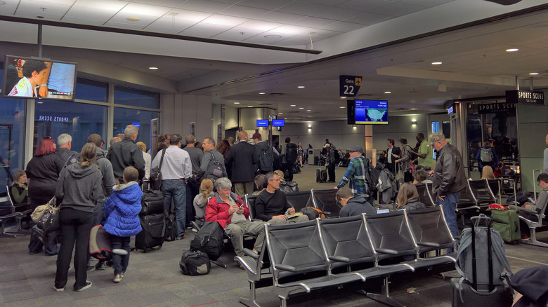 passengers wait in the hold room at Oakland International Airport