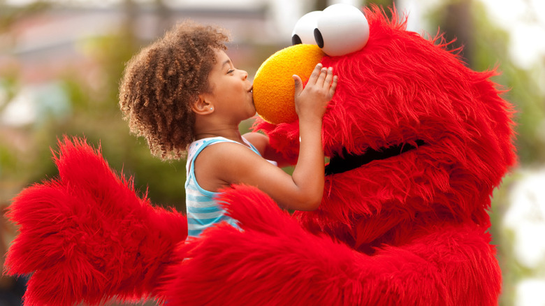 Park guest kissing Elmo's nose