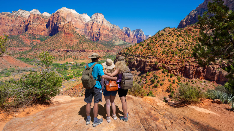 Family on top of the mountain enjoying beautiful view on hiking trip in Utah