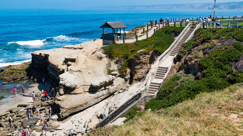 Stairs leading down cliff to beach, people