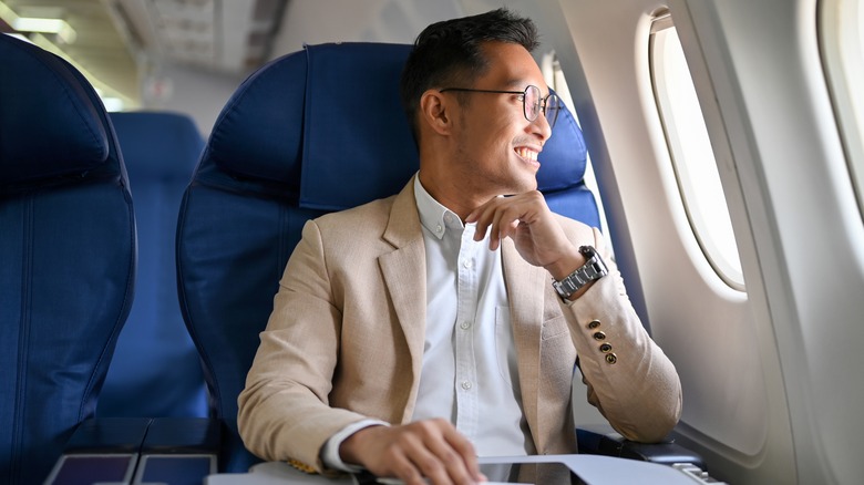 Businessman looking out plane window