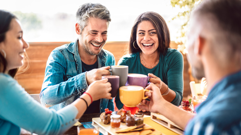 Friends toasting with cappuccinos.