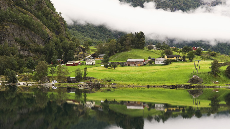 clouds descending over farms in lush green valley