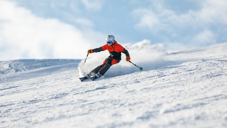A teenager skiing down a snowy mountain.