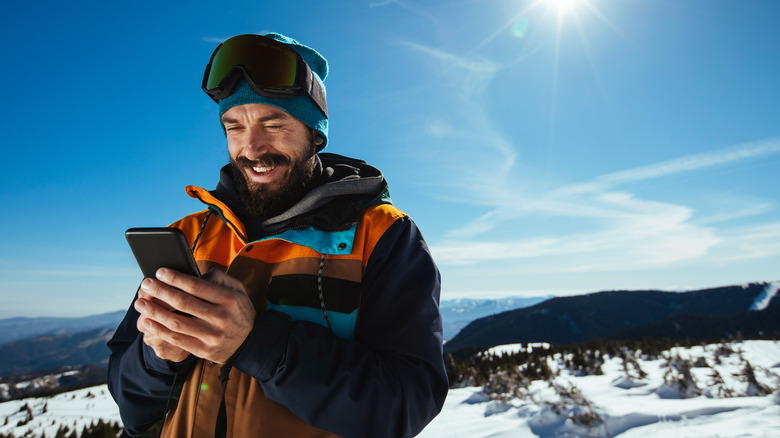 Man skiing using phone