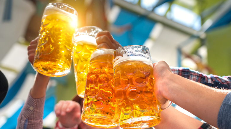 people clinking giant beer mugs