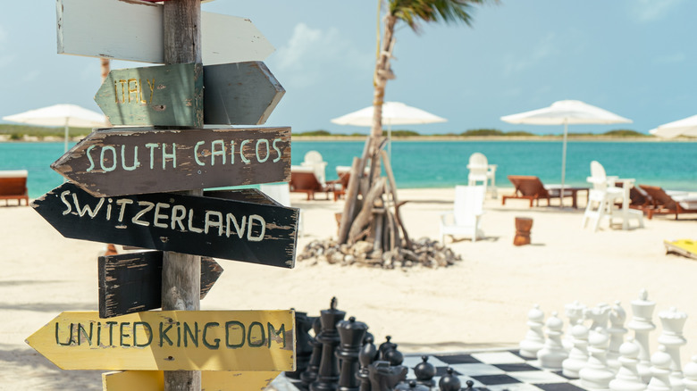 a directional sign next to yard games by the beach