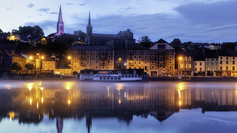 A beautiful Irish village reflecting on a river in the evening