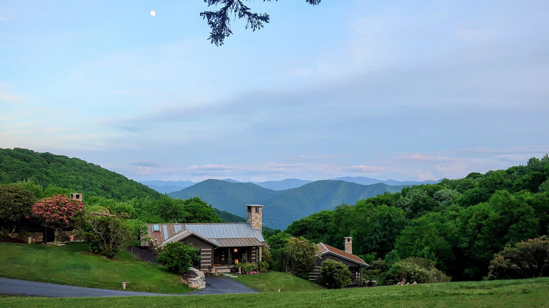 Cabins amid the rolling green hills of the Great Smoky Mountains in Maggie Valley, North Carolina, at Cataloochee Ranch resort.