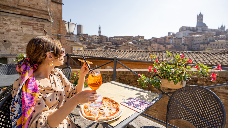 A woman eating pizza in Italy.